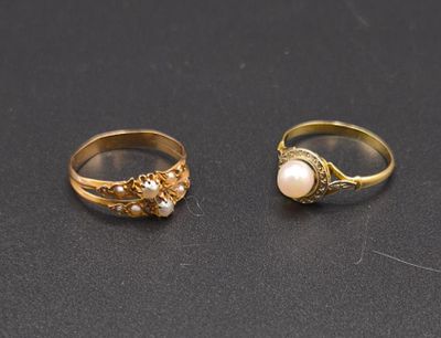 deux bagues en or ornées de perles, posées sur un fond noir