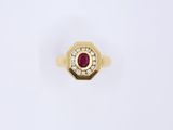 a close up of a gold ring with a ruby and diamonds