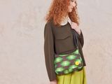 the woman is wearing a green dress and a green purse