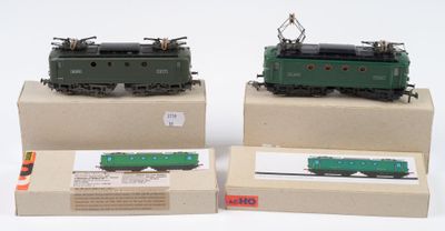trois trains miniatures sont exposés dans des boîtes posées sur une surface blanche
