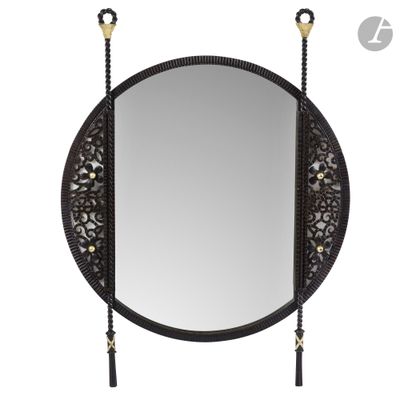 a round mirror with a tassel hanging on the side of it