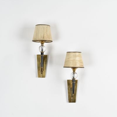 une paire d'appliques en laiton avec des lampes sur un mur blanc