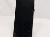 the back of a black cell phone sitting on top of a white table