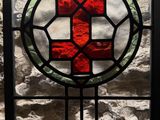 a stained glass window with a red cross on it