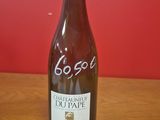 La bouteille de vin est posée sur la table, devant un mur rouge.