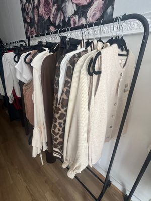 a rack of clothes hanging on a clothes rack in a room