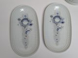 two white plates with decorative designs on them on a table
