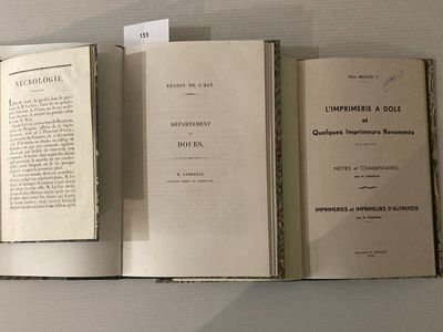 trois livres ouverts posés sur une table