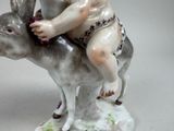 a figurine of a boy riding a cow