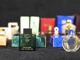 several bottles of perfume are lined up on a black surface