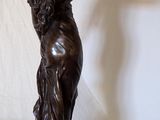 a statue of a woman holding a knife on a table