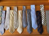 many different ties laid out on a wooden table