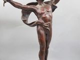 une statue antique en bronze représentant une femme tenant une couronne et un oiseau