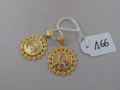 a close up of a pair of gold earrings with a tag