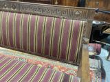 a wooden bench with a striped cushion on it