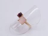 ring with a pink stone and a red garnett on top of a clear ring