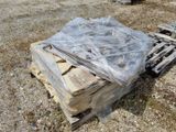 un tas de bois posé sur une palette au milieu d'un champ