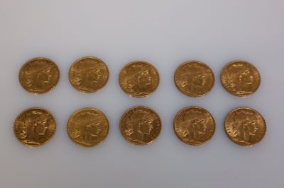 un groupe de pièces d'or posées sur une surface blanche