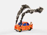 une petite voiture miniature d'où sort de la fumée