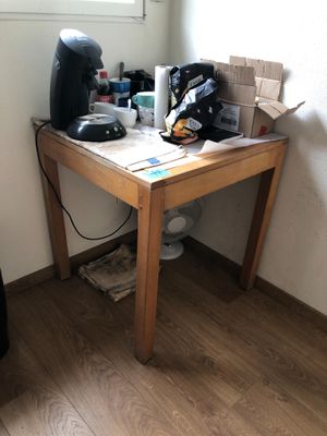 a small table with a coffee maker on it in the corner of a room