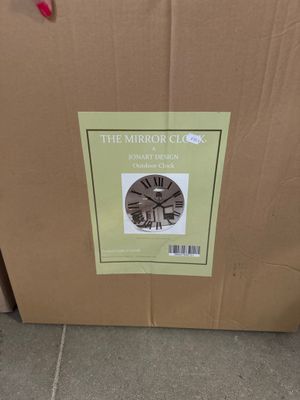 une boîte posée par terre, avec une horloge à l'intérieur