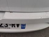 the rear end of a white car with a number plate on it