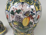 a picture of a vase with a lid and a plate with fruit on it