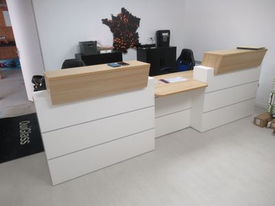 une photo d'un espace d'accueil avec un bureau et deux chaises