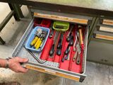 un tiroir contenant des outils, posé sur une table