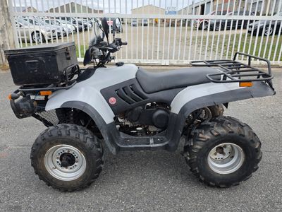une photo d'un quad argenté garé sur un parking