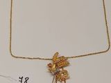 deux colliers en or et un collier orné d'un oiseau