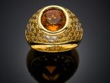 a close up of a gold ring with a large brown stone
