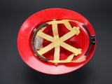 a red hard hat with yellow tape on it