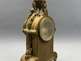 a gold clock that is sitting on a table