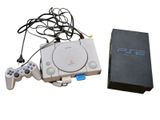 a video game console and a game controller next to a box