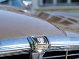 a close up of a car ' s front grill with a building in the background