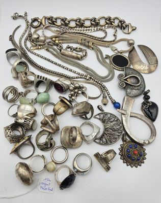 un tas de bijoux en argent posés sur une surface blanche