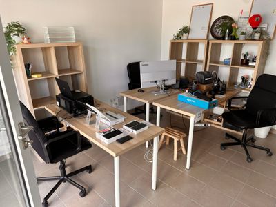 un bureau avec deux ordinateurs et une chaise dans une pièce