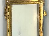 un miroir avec un cadre doré sur le mur