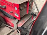 a red machine that is sitting on top of a pile of luggage