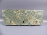 green marble block with holes in it on a white surface