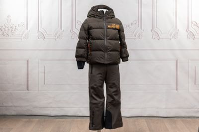 un manteau et un pantalon posés sur un mannequin dans une pièce