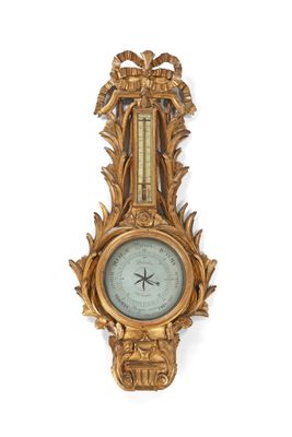 une horloge dorée accrochée au mur, à côté d'un mur blanc