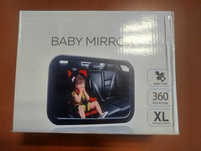 La boîte du miroir pour bébé est ouverte sur la table.