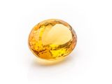 a yellow sapphire stone on a white background