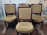 quatre chaises aux assises rembourrées dans une pièce, avec un mur en arrière-plan