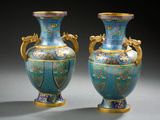 pair of blue and gold vases sitting on a gray surface