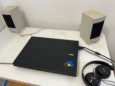 un ordinateur portable et un casque posés sur un bureau équipé d'un écran