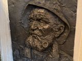 une statue représentant un homme avec une pipe à la bouche