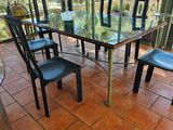 une table en verre avec des chaises et un vase posé dessus